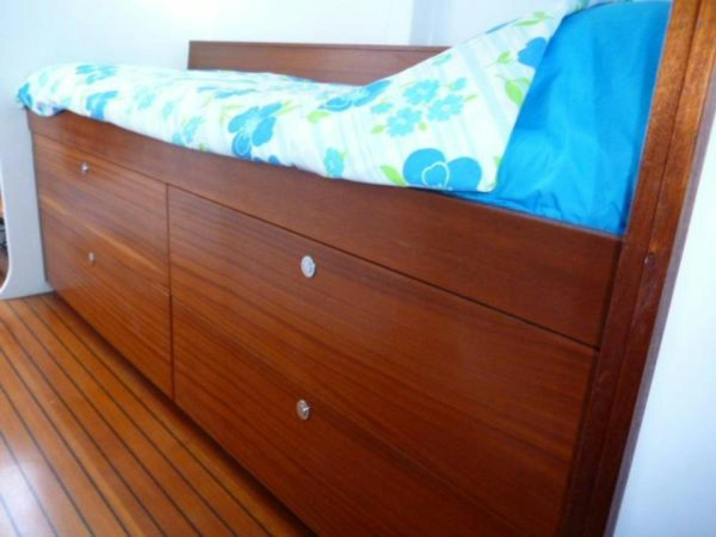 a wooden dresser with a blue and white pillow aboard No Name Yacht for Sale