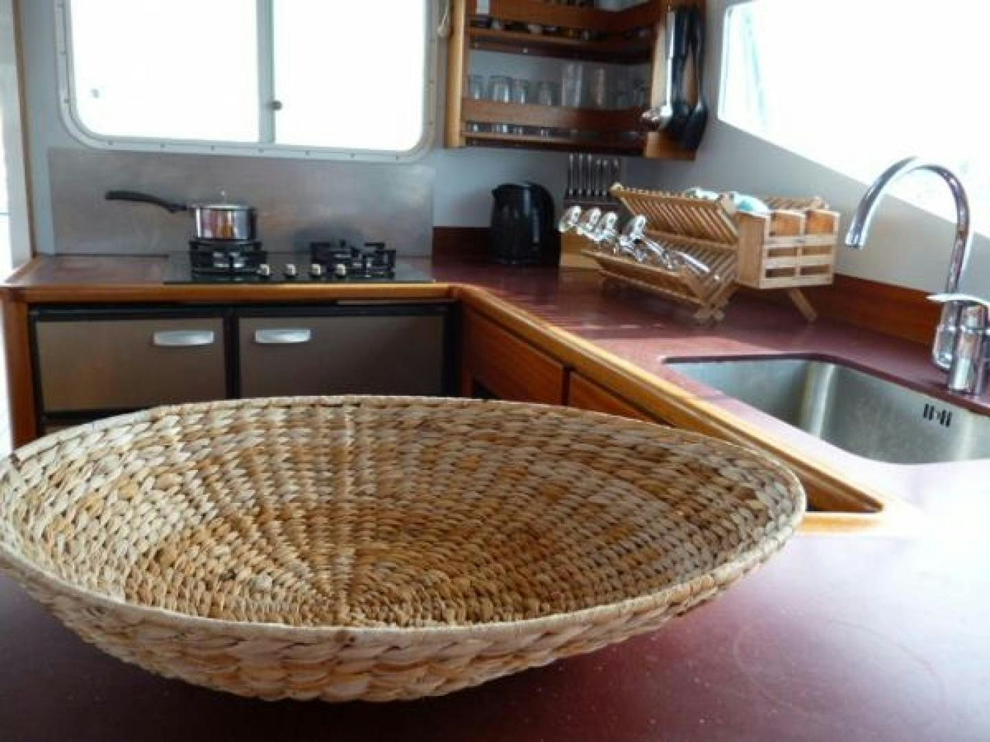 a kitchen with a sink and a basket of bread aboard No Name Yacht for Sale