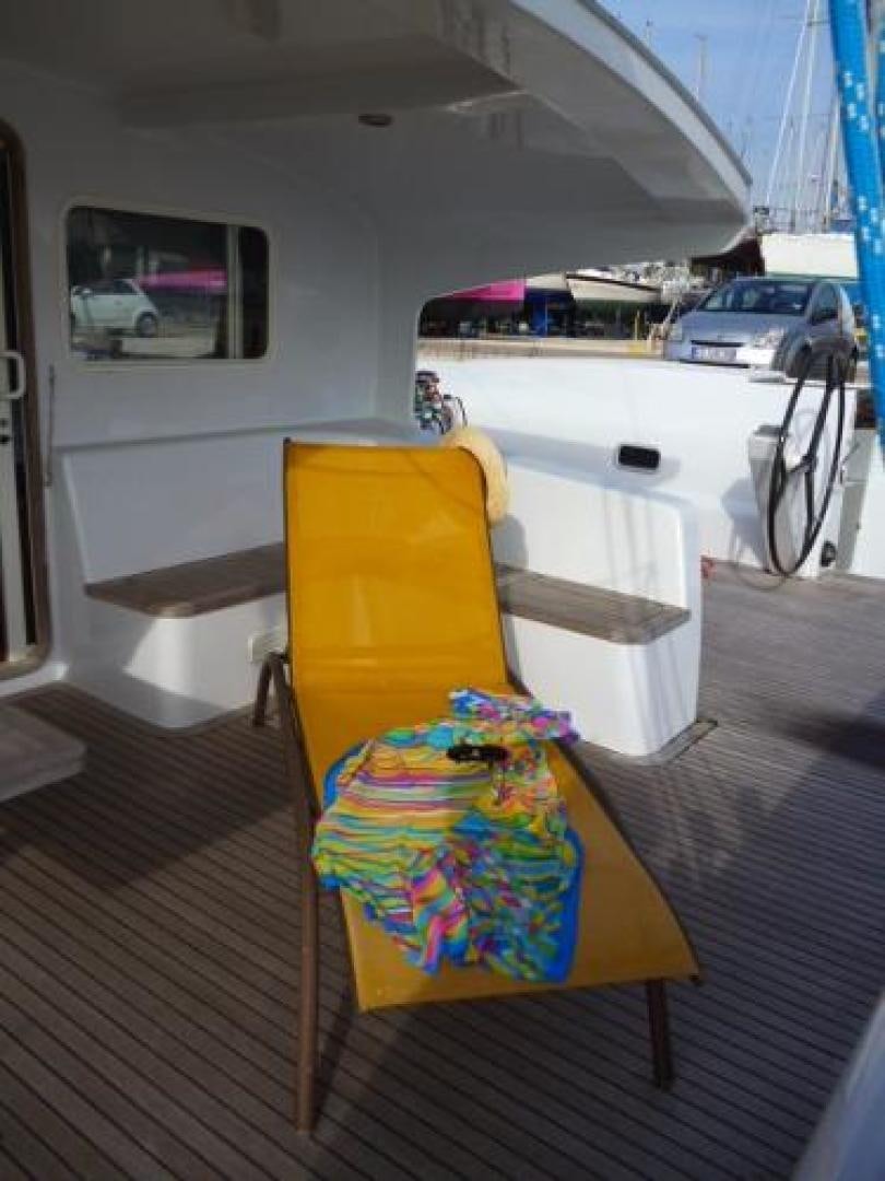 a yellow chair on a deck aboard No Name Yacht for Sale