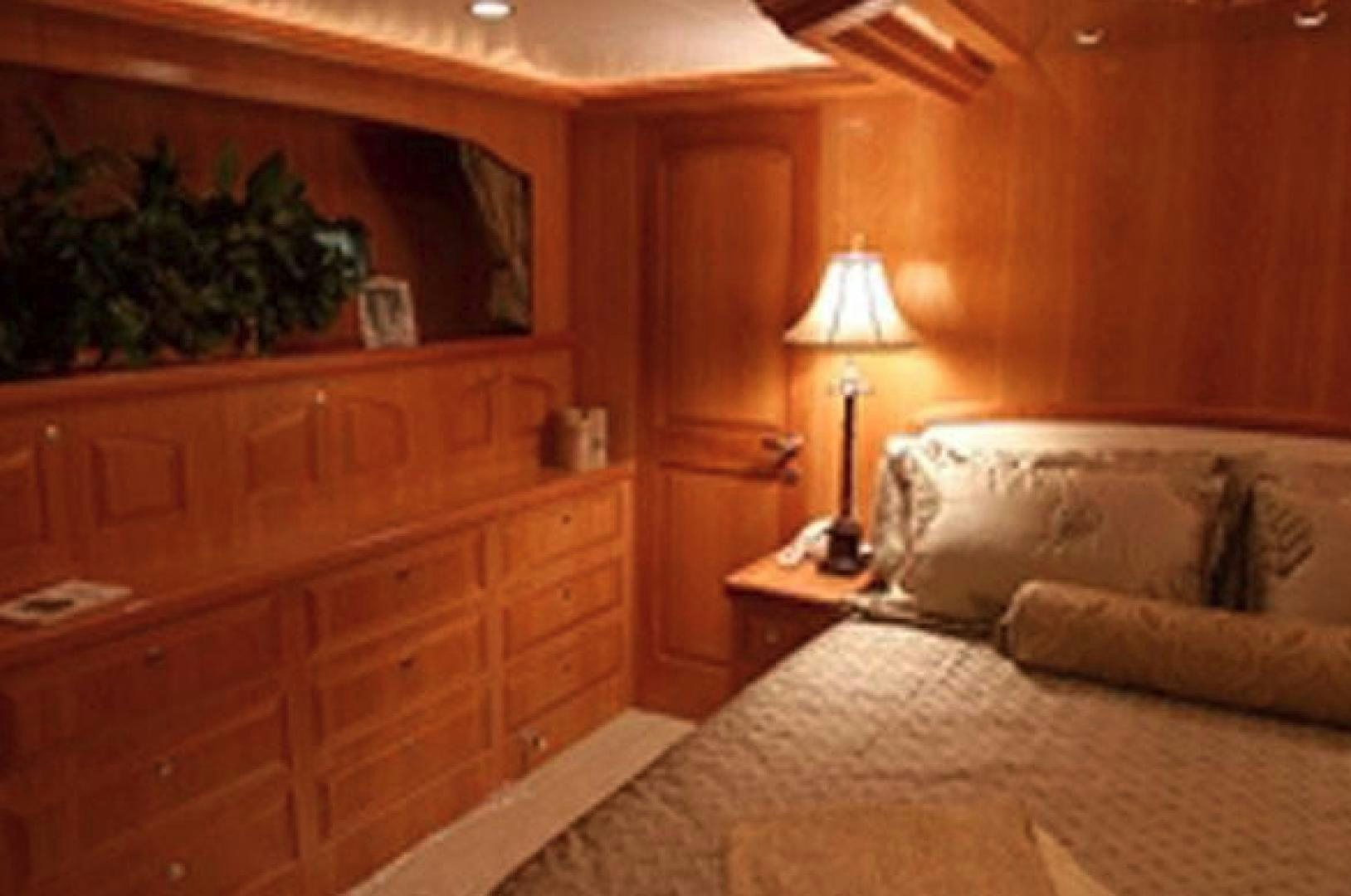 a bedroom with a bed and a lamp aboard No Name Yacht for Sale