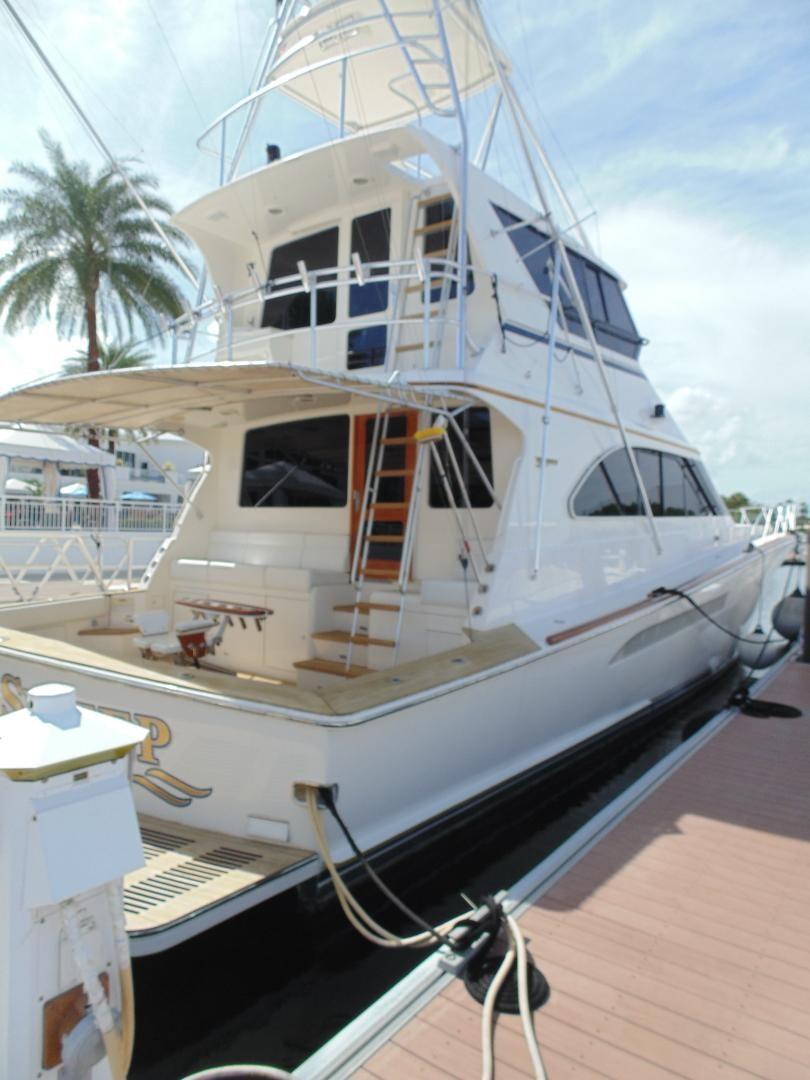a white boat on a dock aboard clean sweep Yacht for Sale