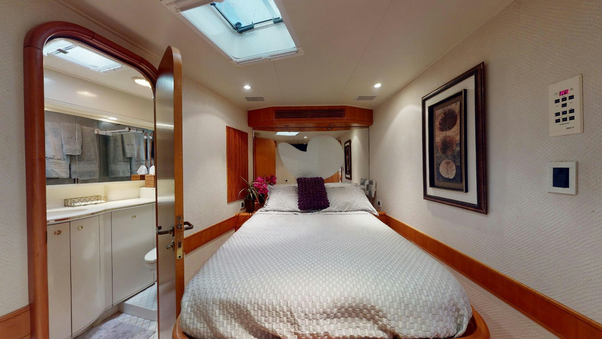 a bedroom with a bed and a mirror aboard clean sweep Yacht for Sale