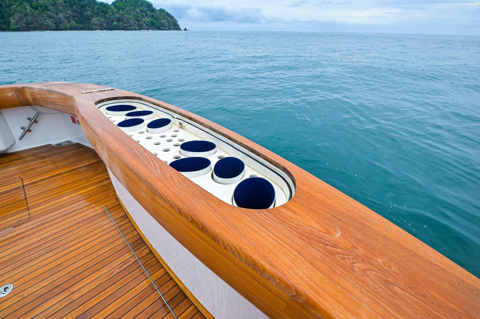 a white rectangular object on a wooden surface next to a body of water aboard GOOSE Yacht for Sale