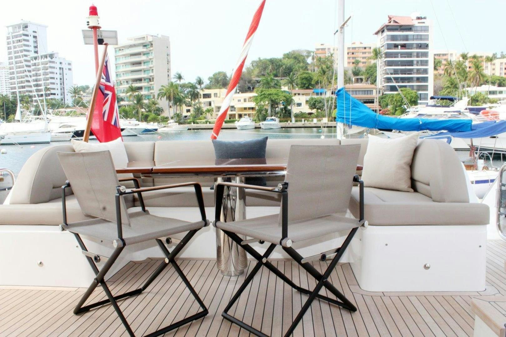 a deck with chairs and a table on it aboard PICHOS III Yacht for Sale