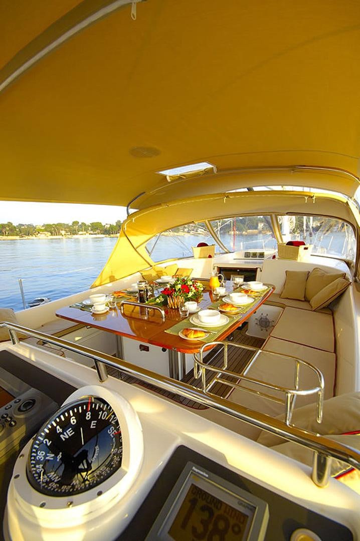 a boat with a table and chairs aboard HOLO KAI Yacht for Sale