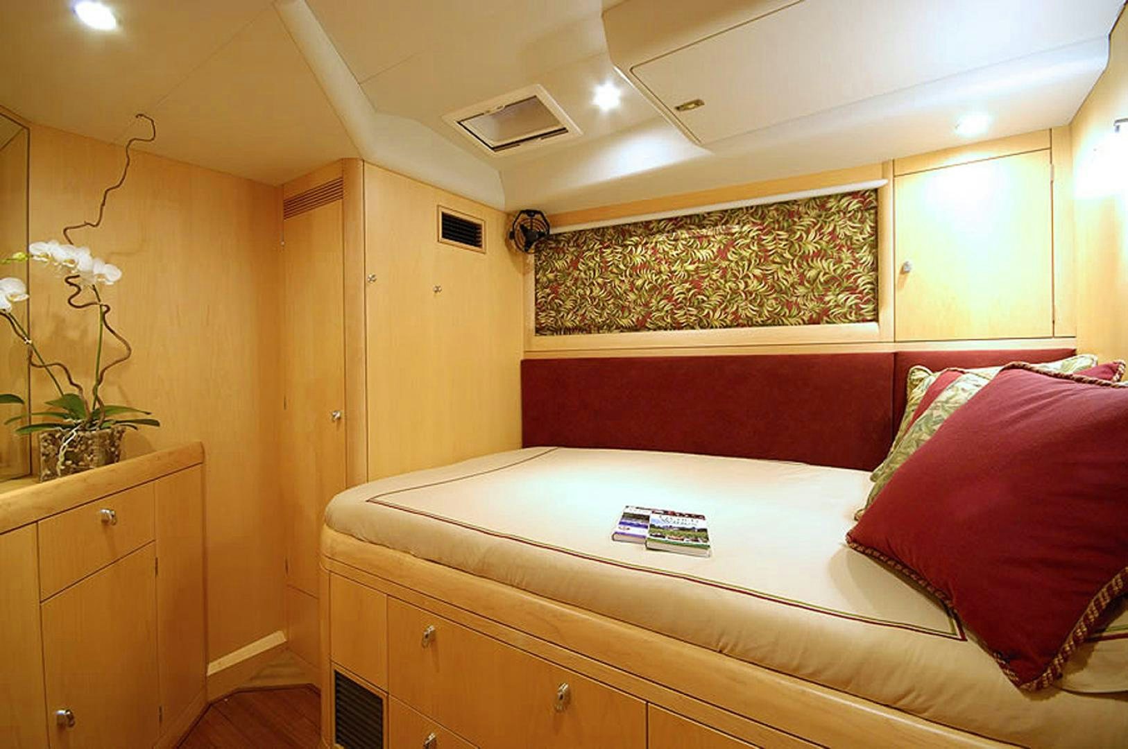 a bed with red pillows aboard HOLO KAI Yacht for Sale