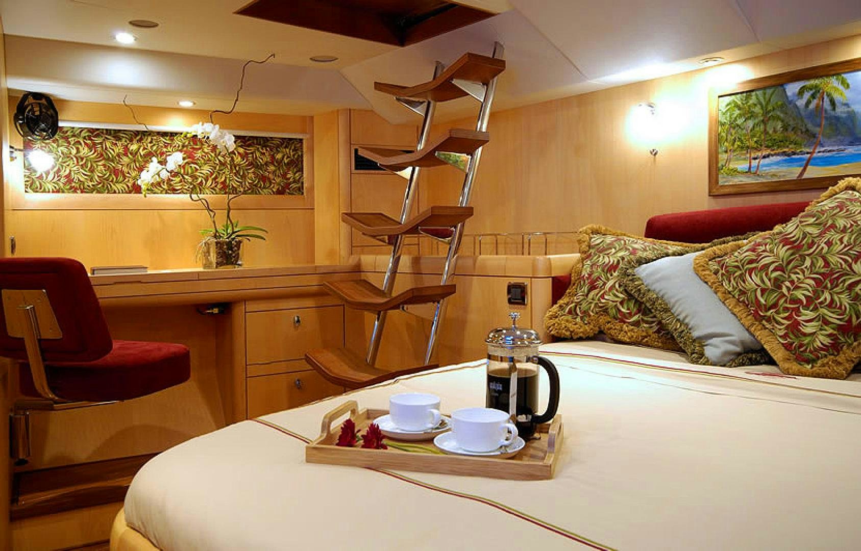 a table with a coffee maker and a chair in a room aboard HOLO KAI Yacht for Sale