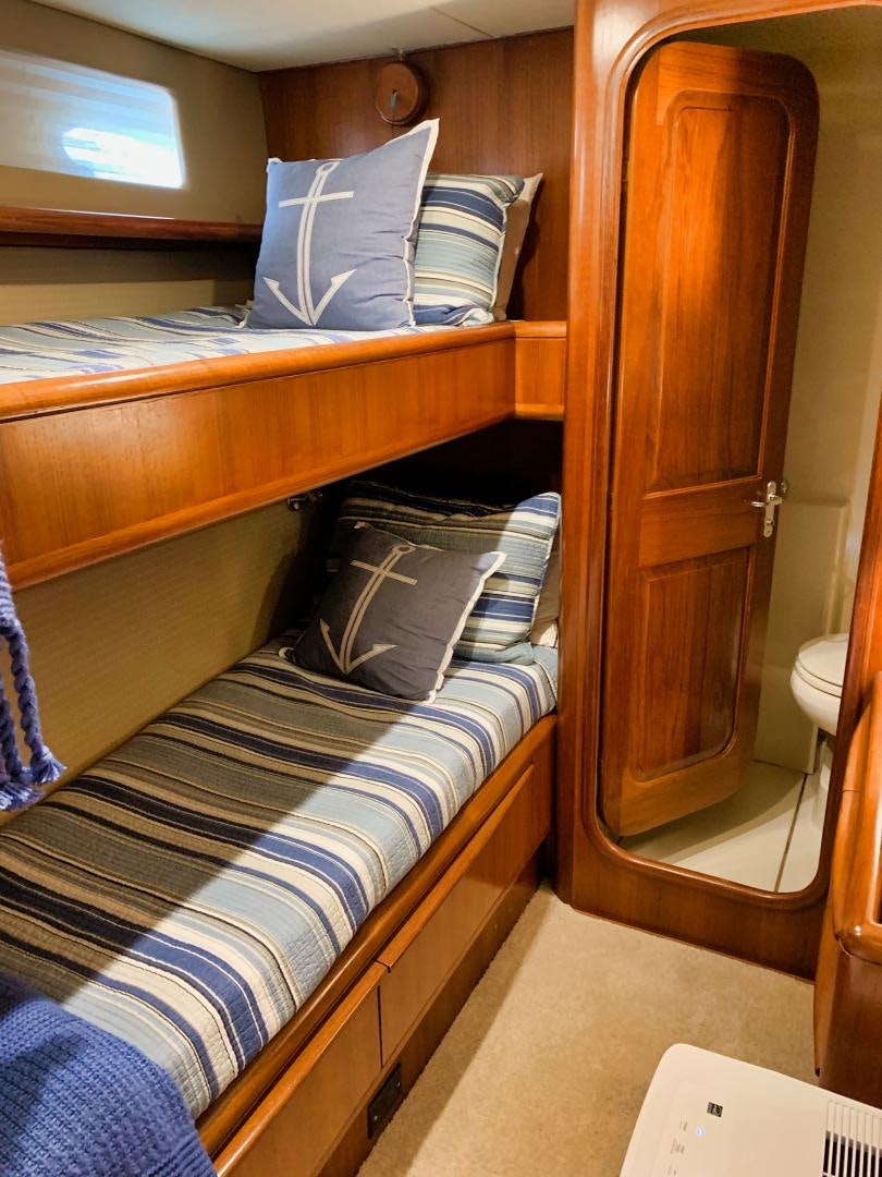 a bed with a wooden headboard aboard SIMPLICITY Yacht for Sale