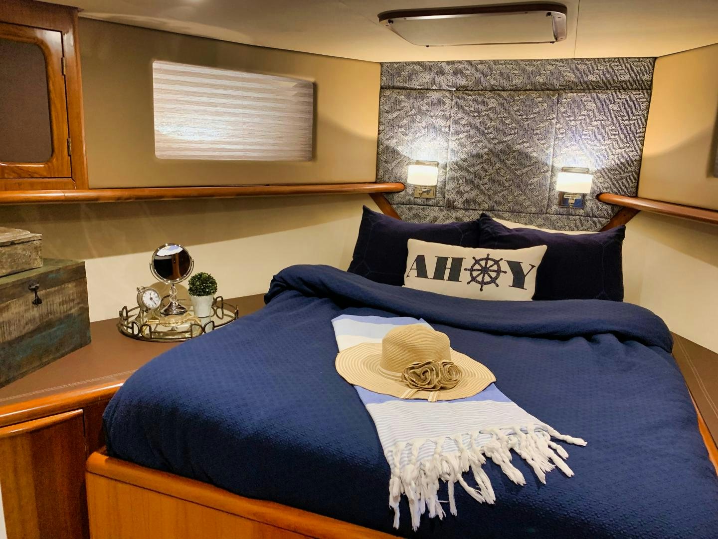a bed with a blue blanket and a white hat on it aboard SIMPLICITY Yacht for Sale
