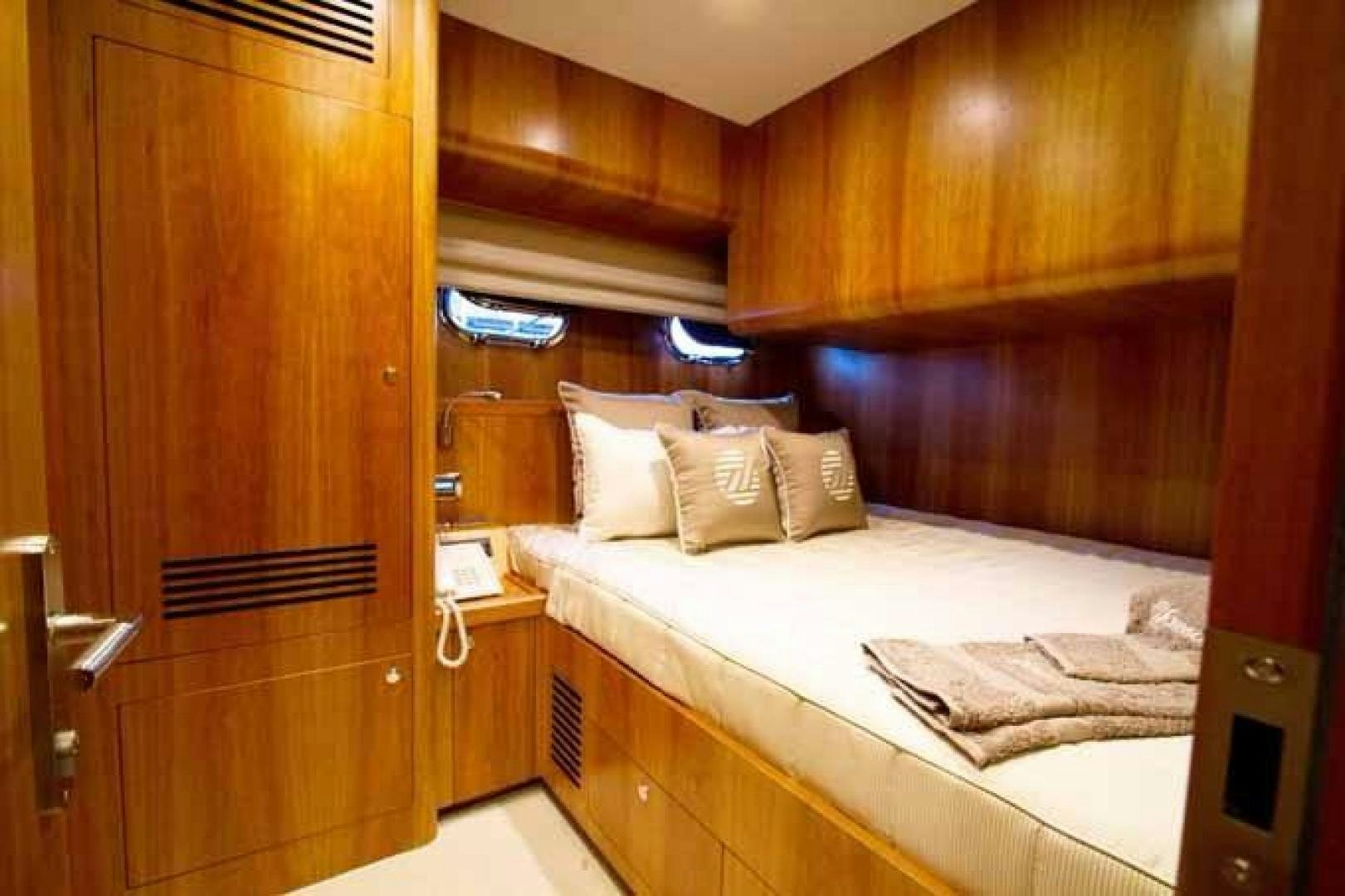 a room with a bed and a wood cabinet aboard JOHNSON 70 SKYLOUNGE NEW BUILD Yacht for Sale