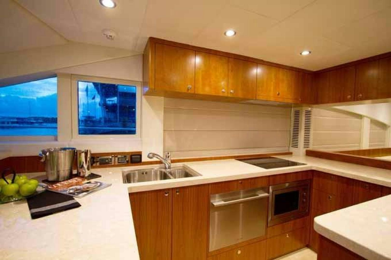 a kitchen with wooden cabinets aboard JOHNSON 70 SKYLOUNGE NEW BUILD Yacht for Sale