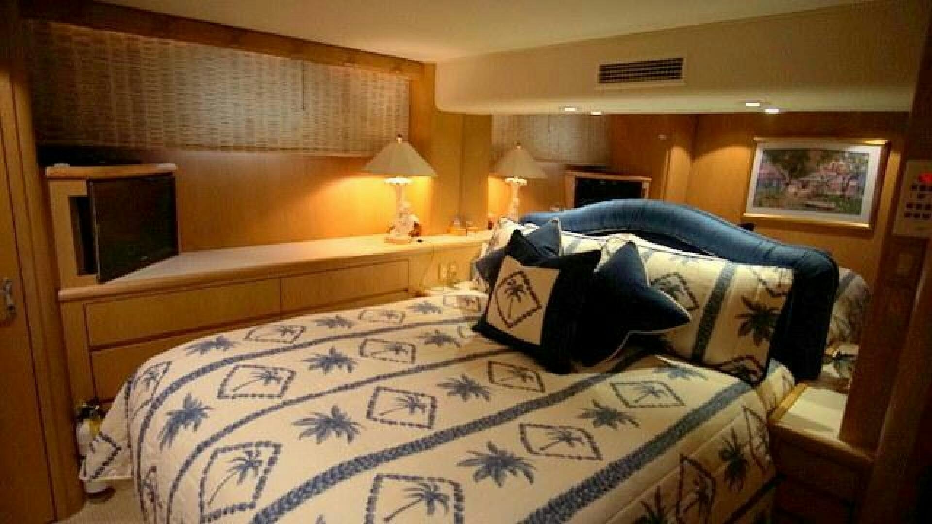 a bed with a blue and white comforter and a black pillow aboard SILVER SEAS Yacht for Sale