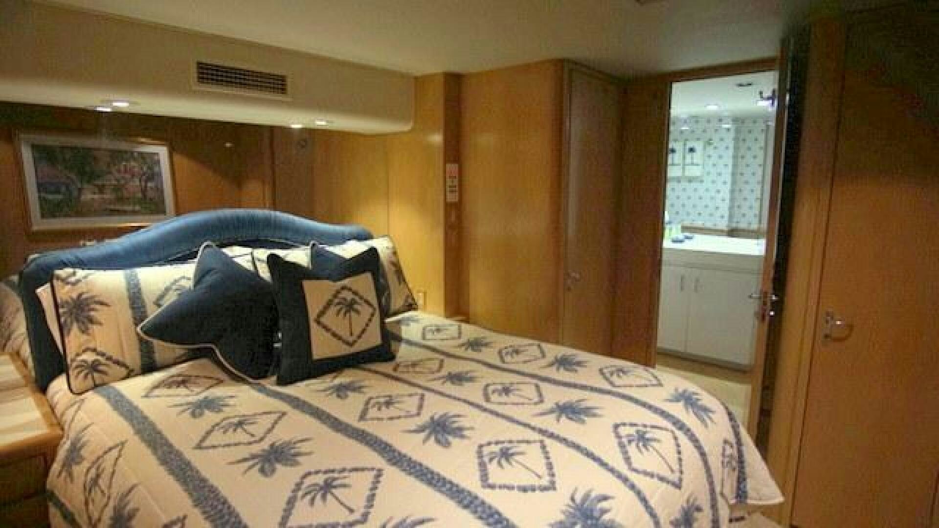 a bed with blue and white sheets aboard SILVER SEAS Yacht for Sale