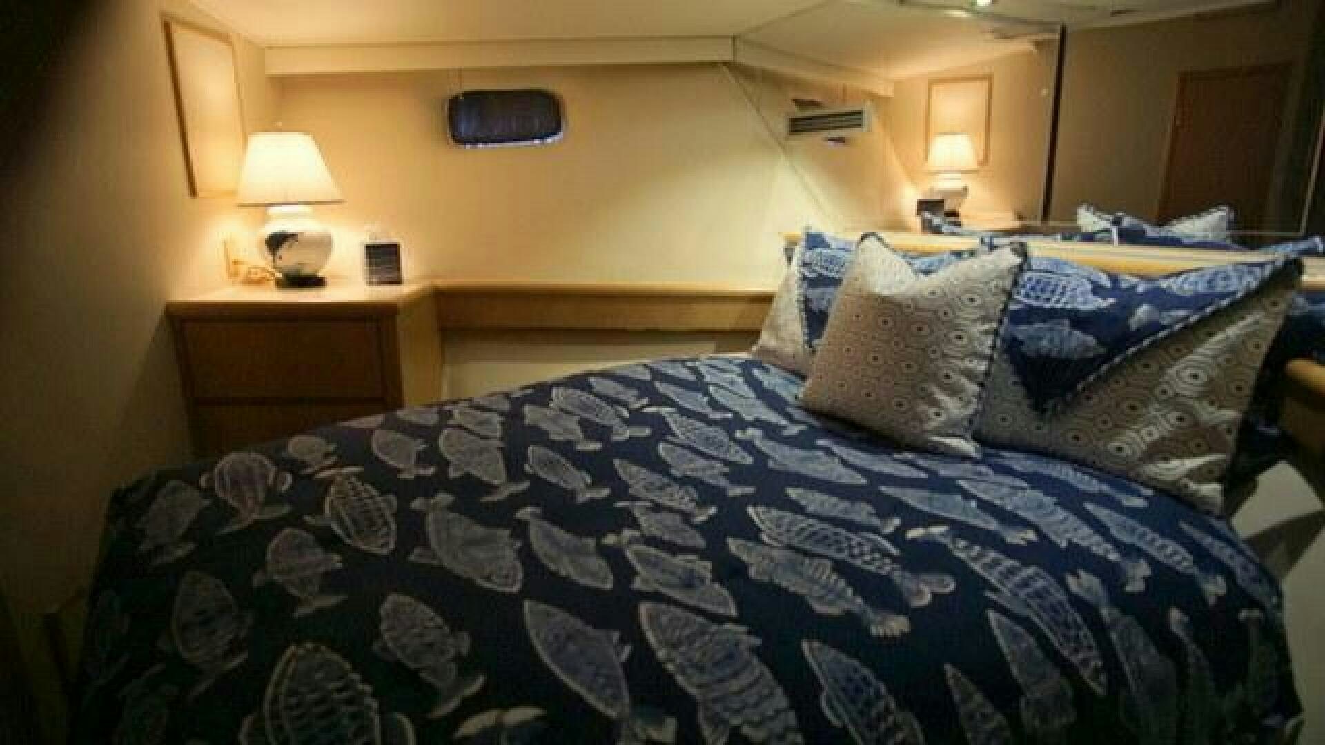 a bed with blue and white sheets aboard SILVER SEAS Yacht for Sale