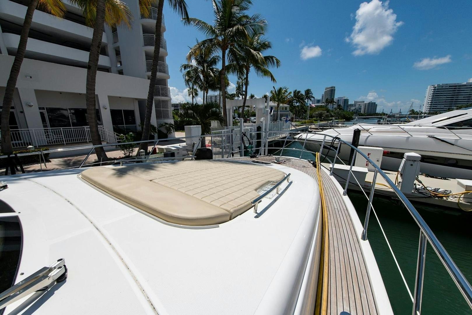 a pool with a deck and a city in the background aboard SOMEWHERE I BELONG Yacht for Sale
