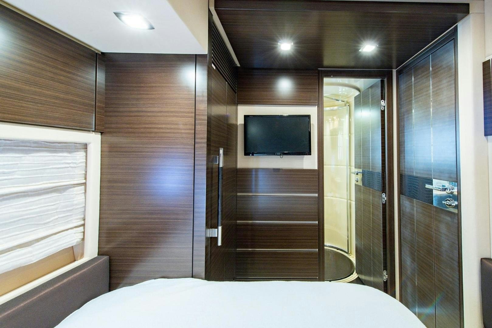 a room with a bed and a television aboard SOMEWHERE I BELONG Yacht for Sale