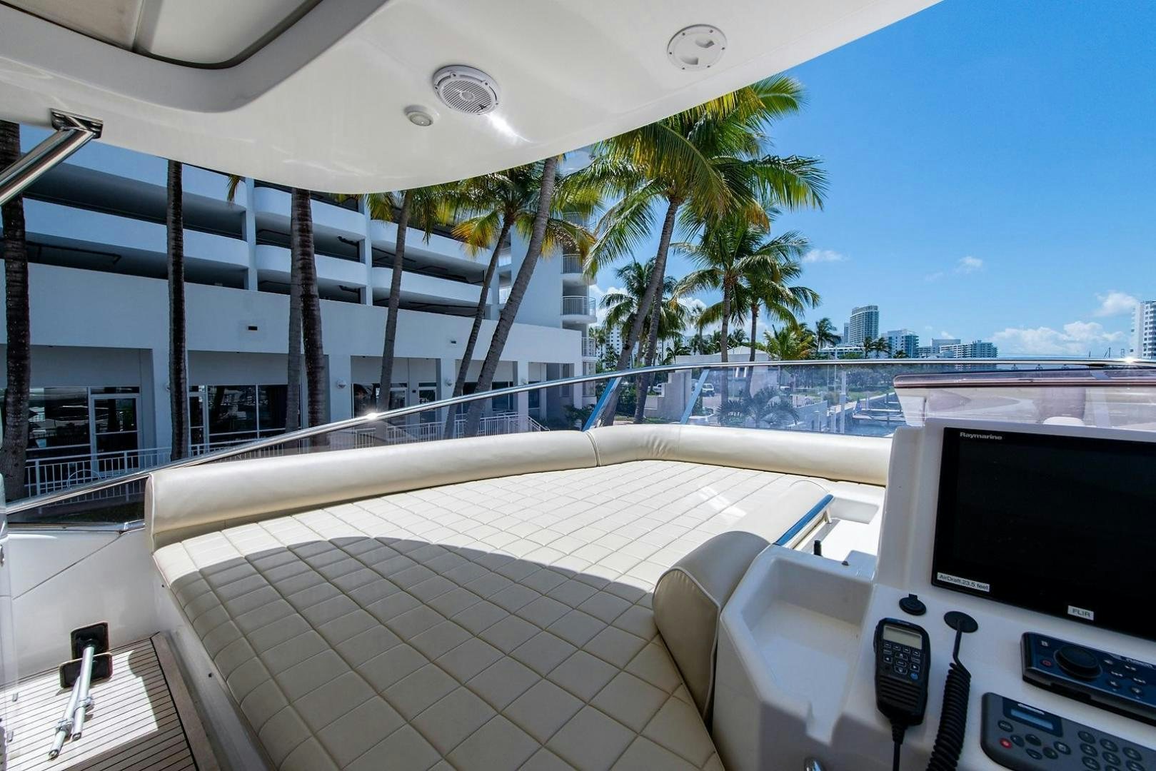 a deck with a large white boat and palm trees aboard SOMEWHERE I BELONG Yacht for Sale