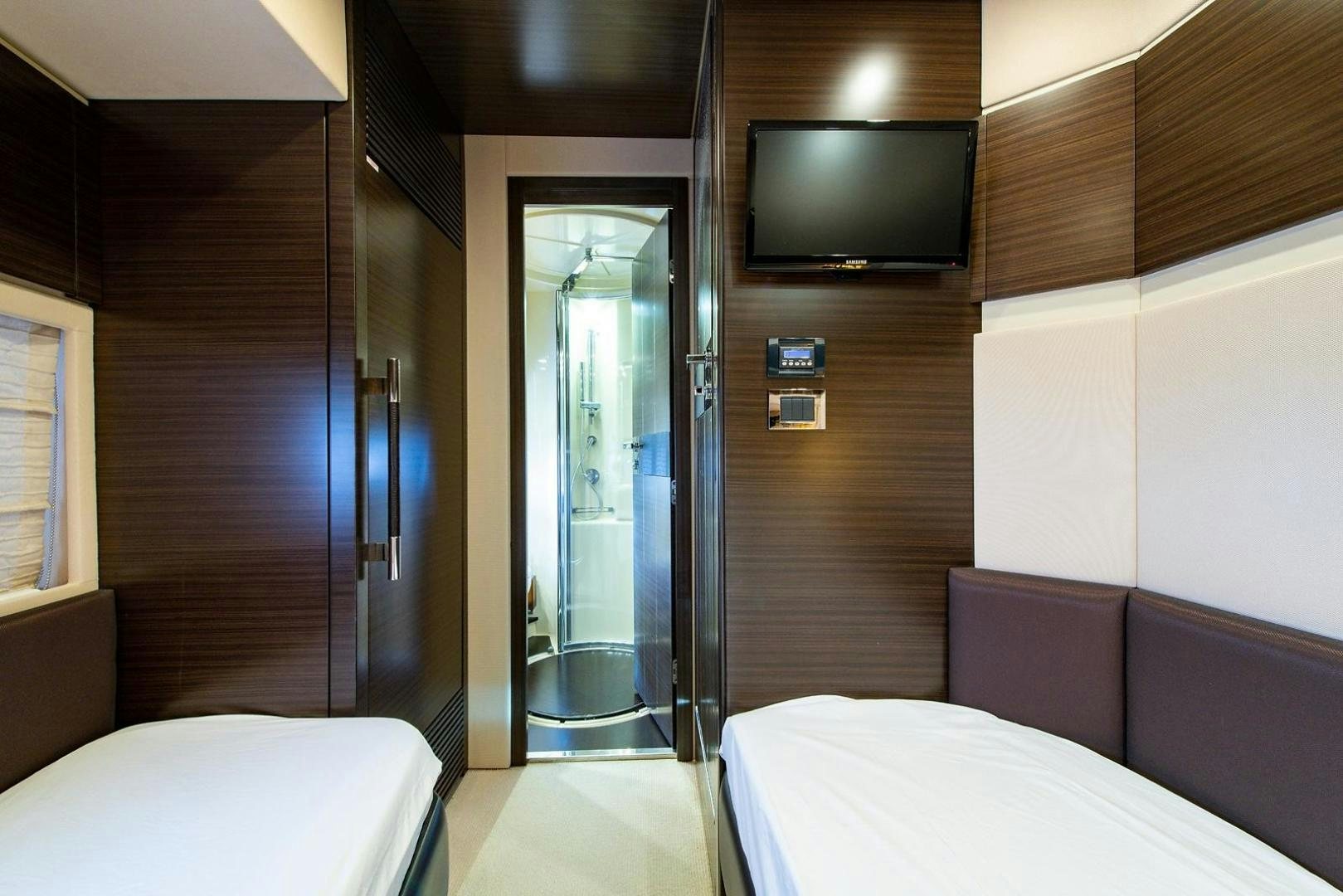 a room with a bed and a television aboard SOMEWHERE I BELONG Yacht for Sale