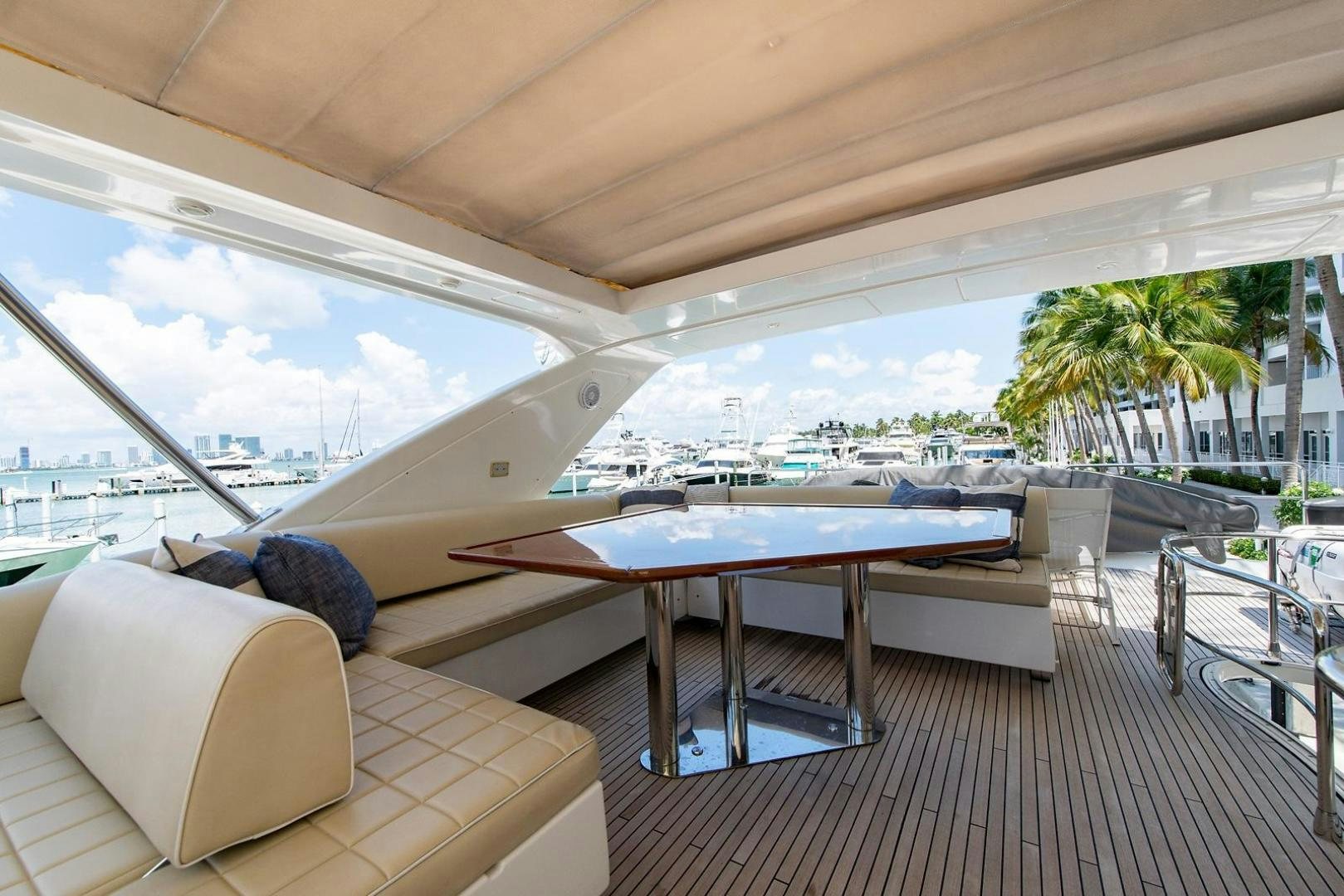 a deck with a pool and a table and chairs aboard SOMEWHERE I BELONG Yacht for Sale