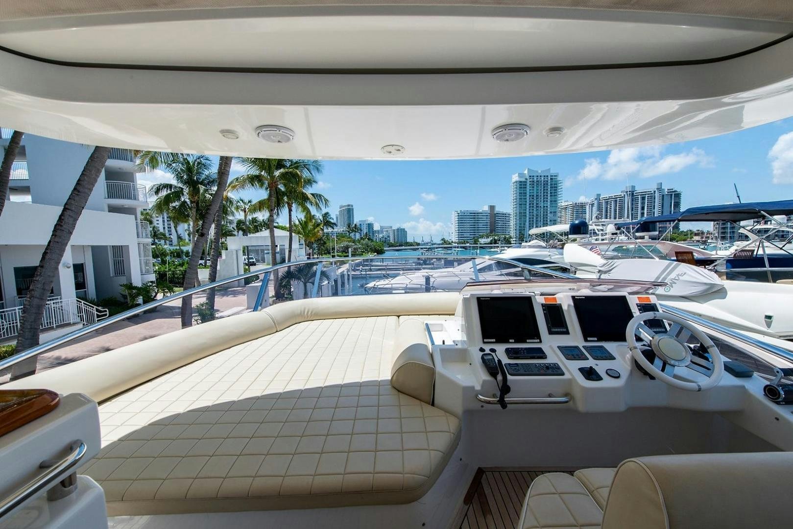 a deck with a boat and a city in the background aboard SOMEWHERE I BELONG Yacht for Sale