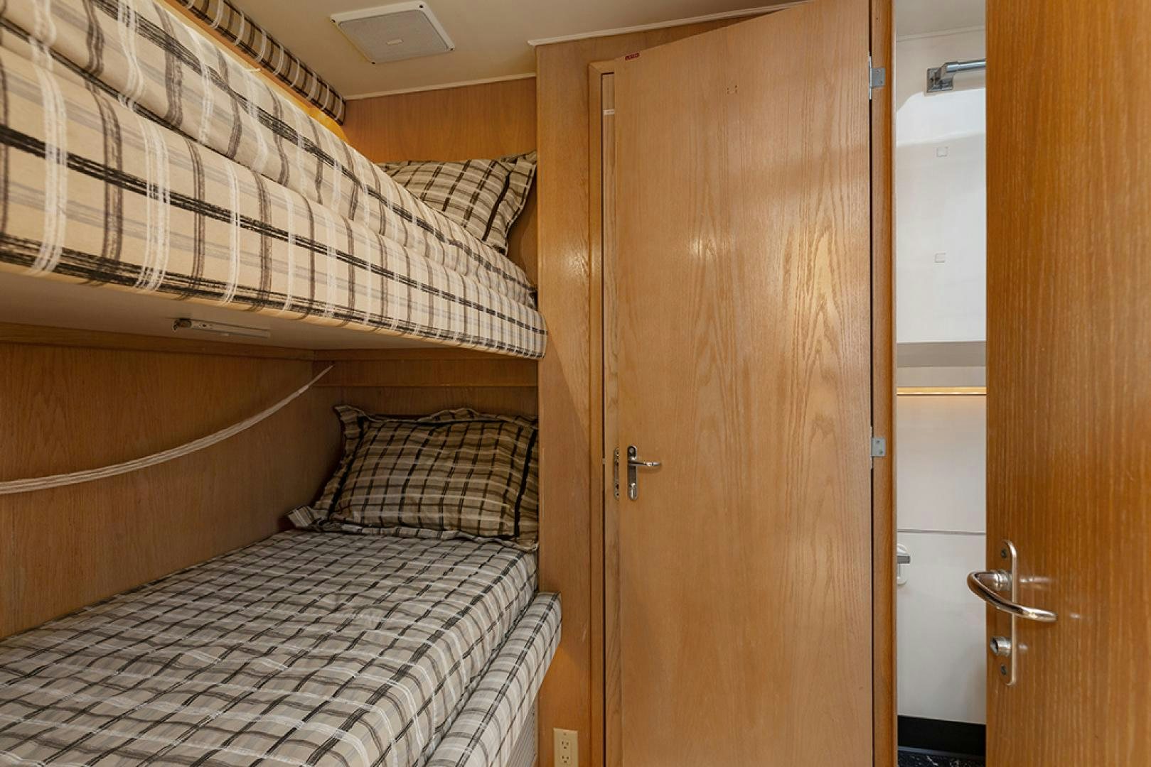 a room with a bed and a door aboard DAYDREAMER IV Yacht for Sale