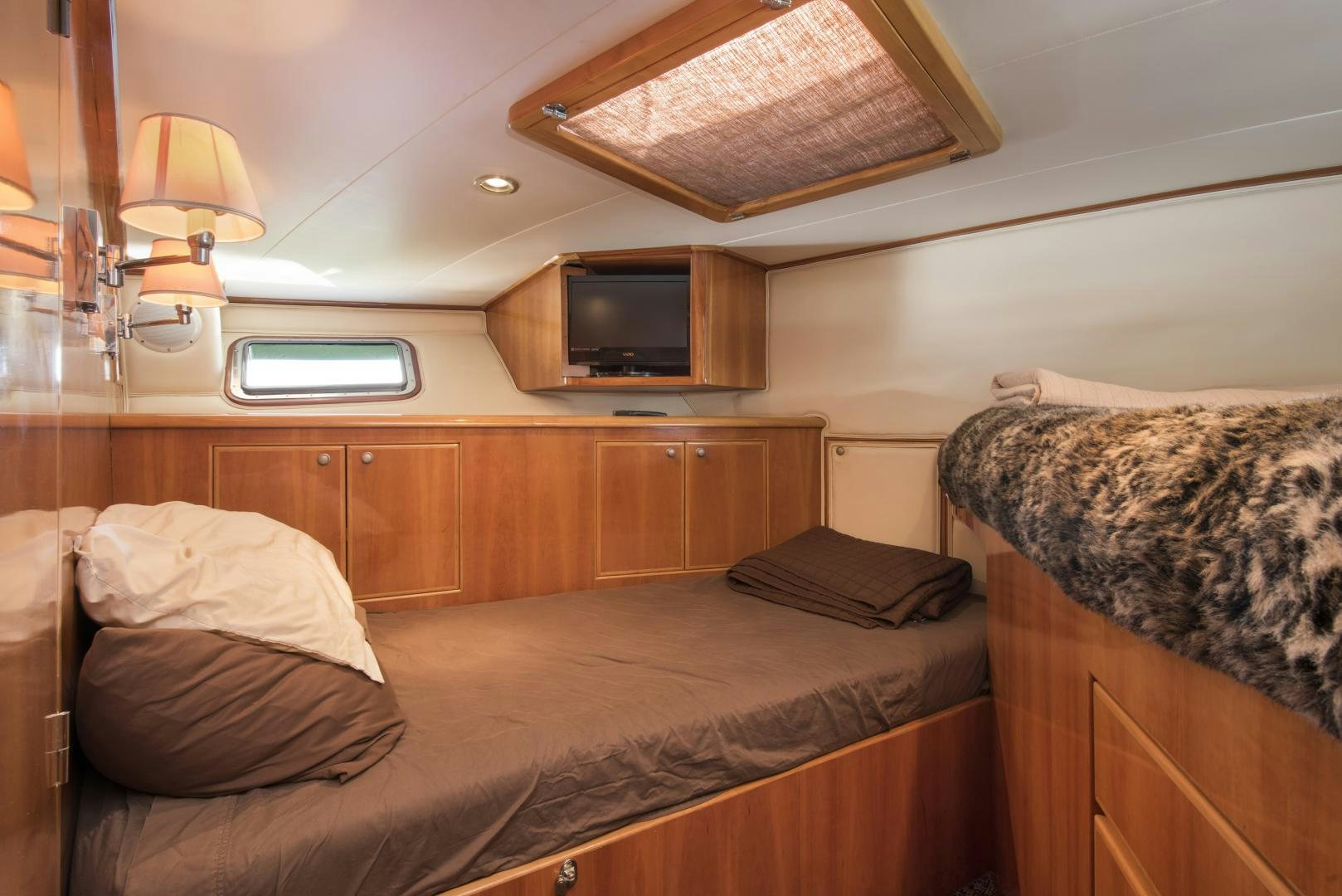 a bedroom with a bed and a television aboard LEGACY Yacht for Sale