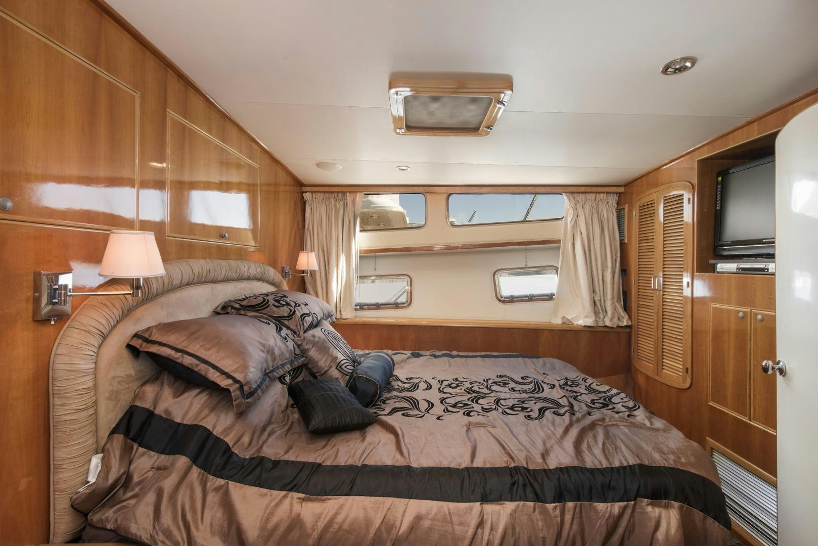 a bedroom with a bed and a television aboard LEGACY Yacht for Sale