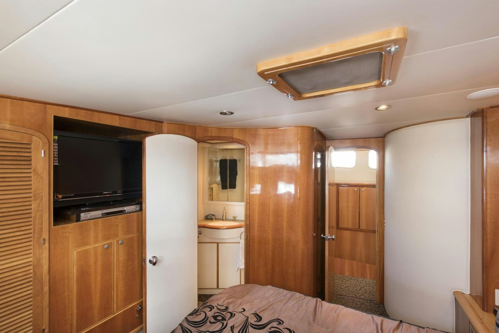 a bedroom with a bed and a television aboard LEGACY Yacht for Sale