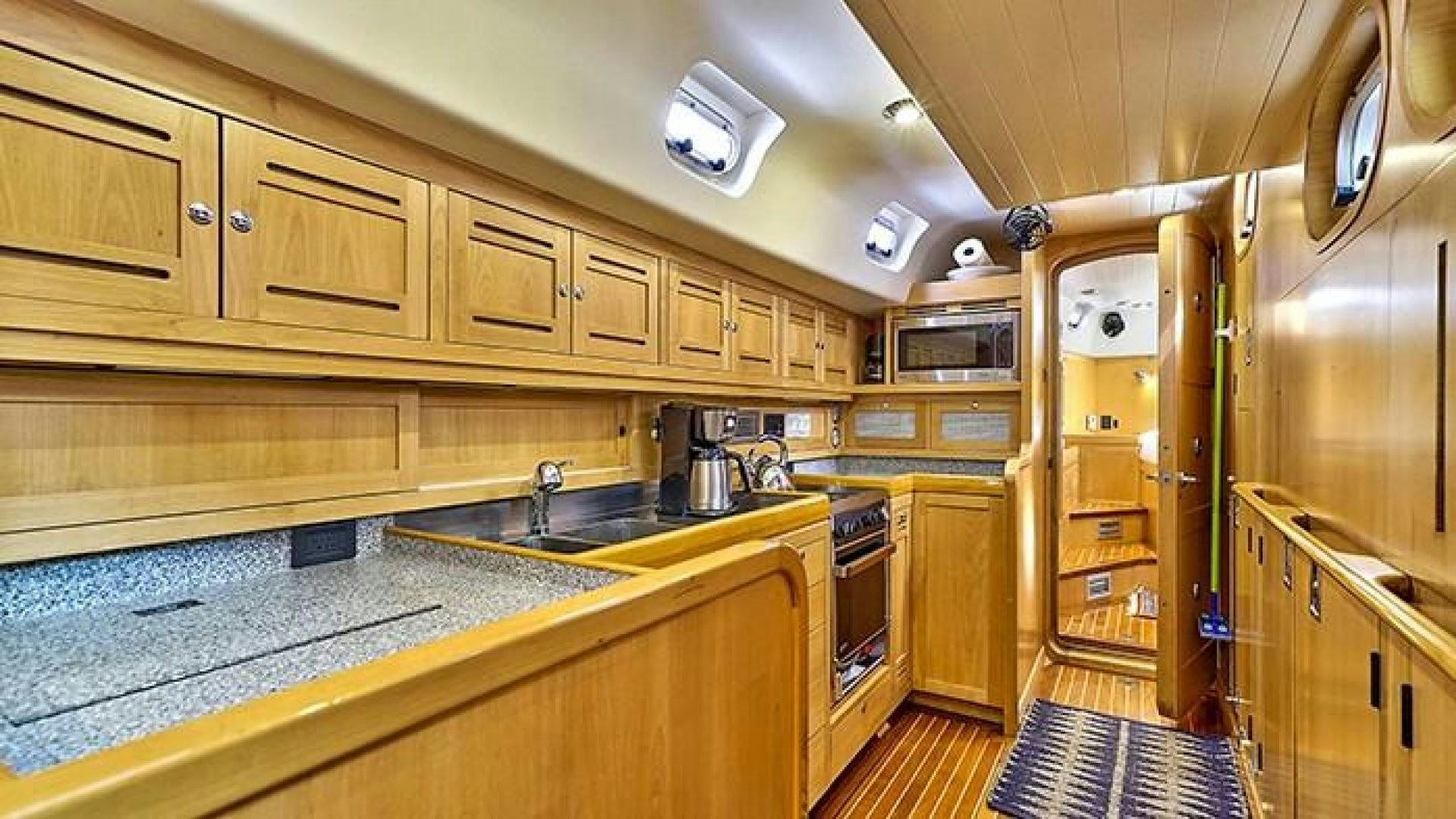 a kitchen with wooden cabinets aboard MAYA Yacht for Sale