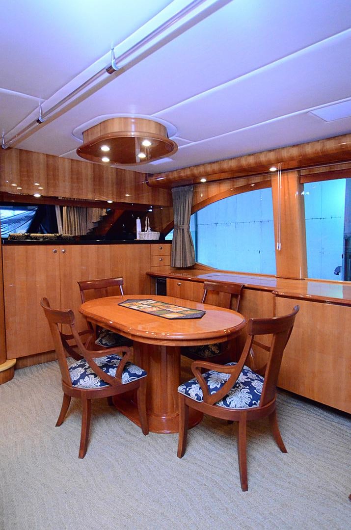 a wooden table and chairs in a room with a window aboard 4 PRINCESSES Yacht for Sale