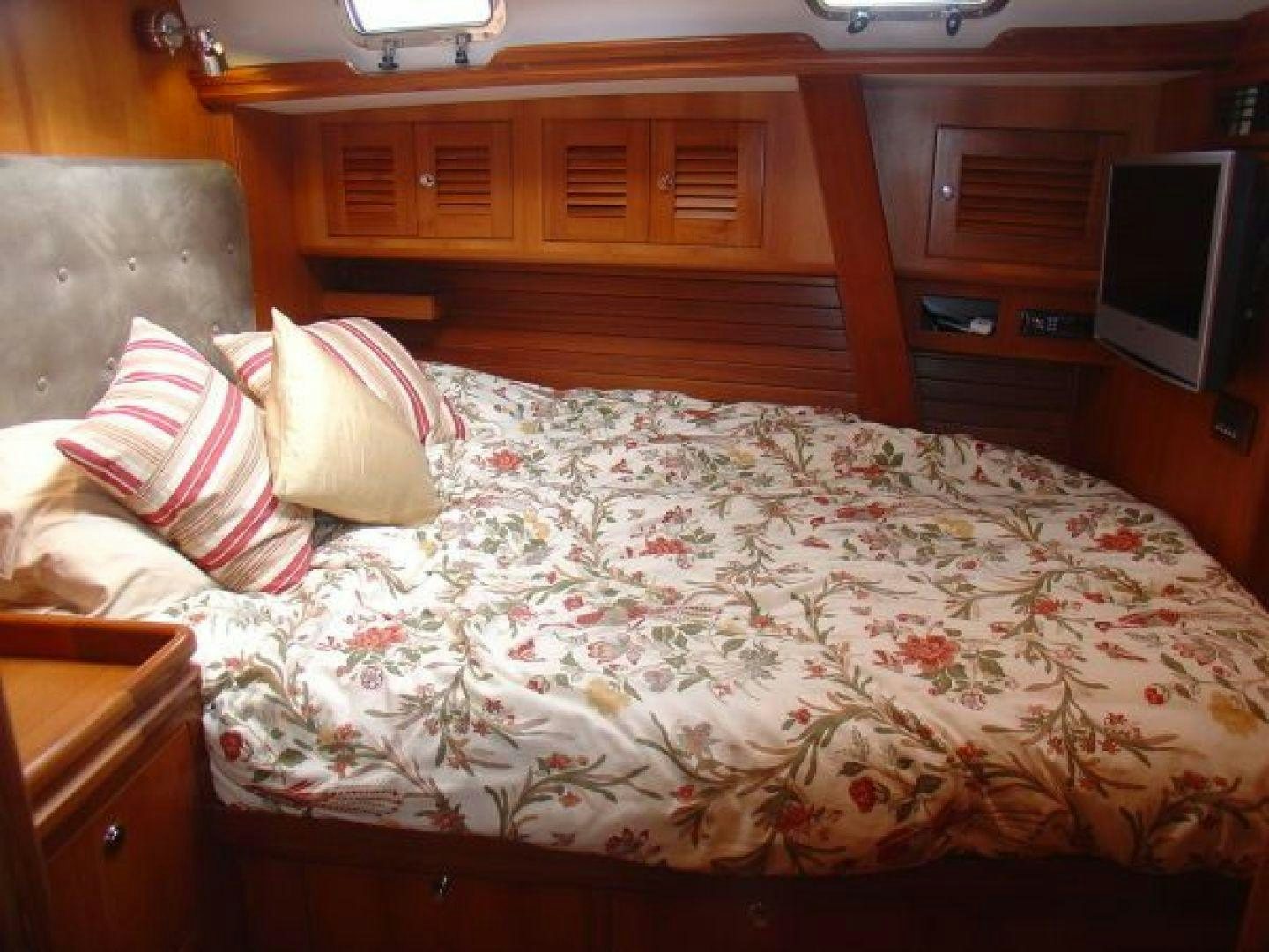 a bed with a white comforter and pillows aboard amante Yacht for Sale