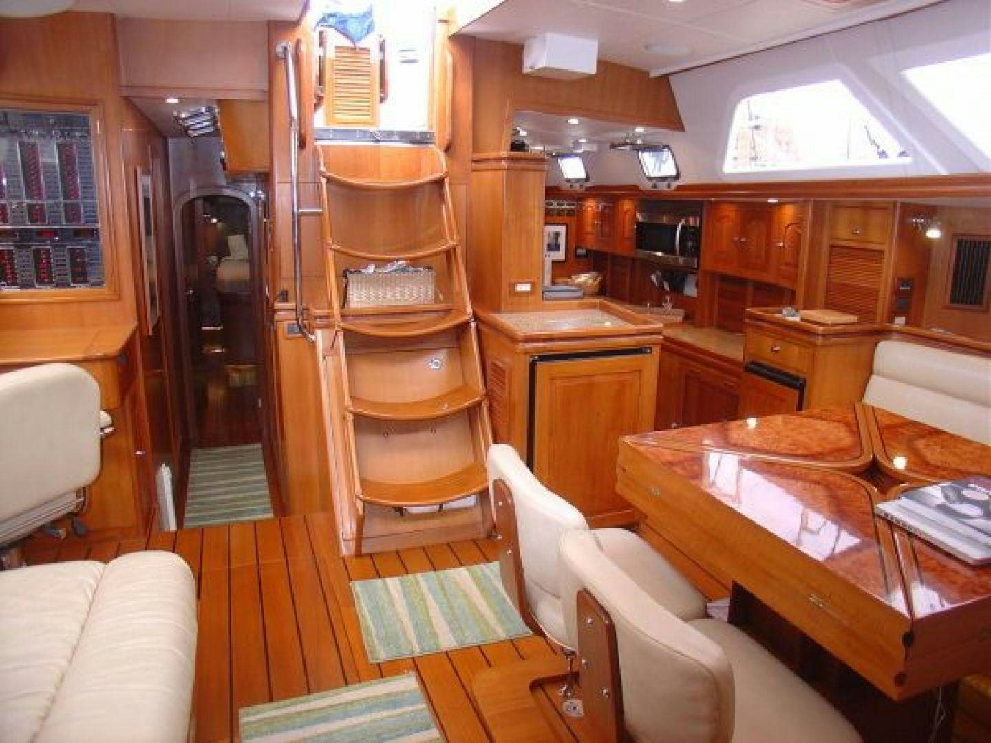 a room with a wood cabinet and chairs aboard amante Yacht for Sale