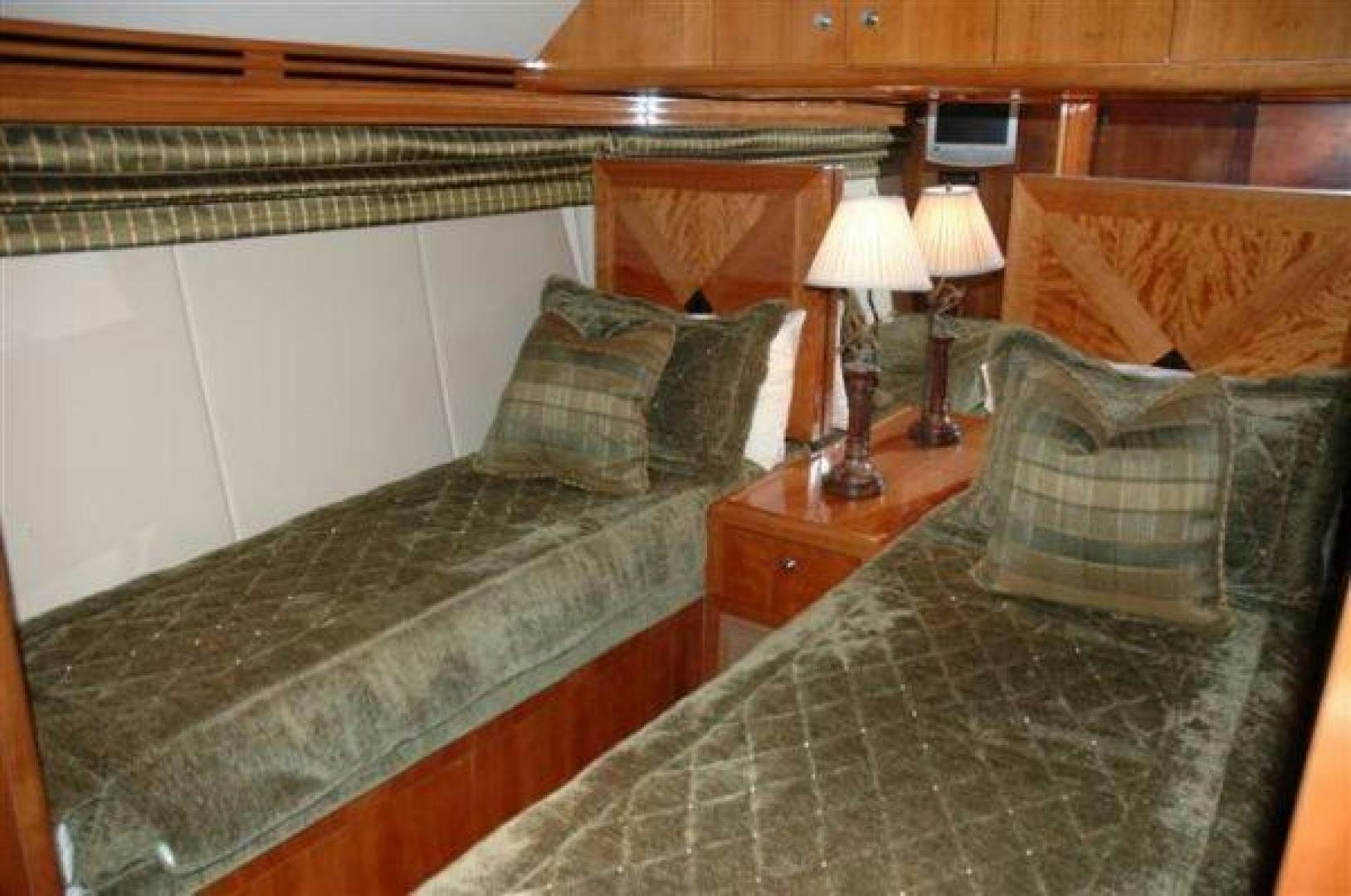 a bed with a green comforter and pillows aboard SOLE RETREAT Yacht for Sale