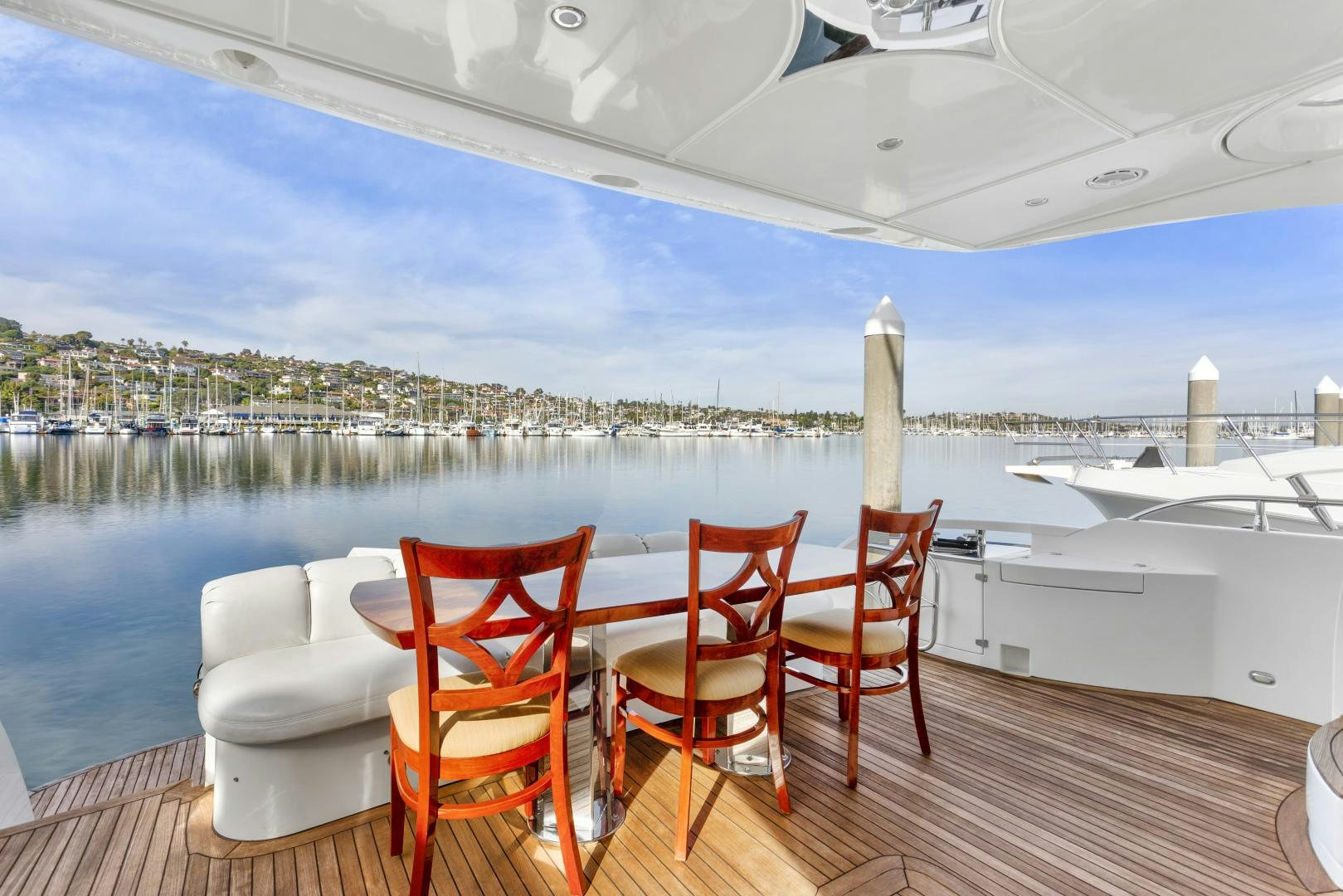 a deck with chairs and a table on it aboard MONDRIAN Yacht for Sale