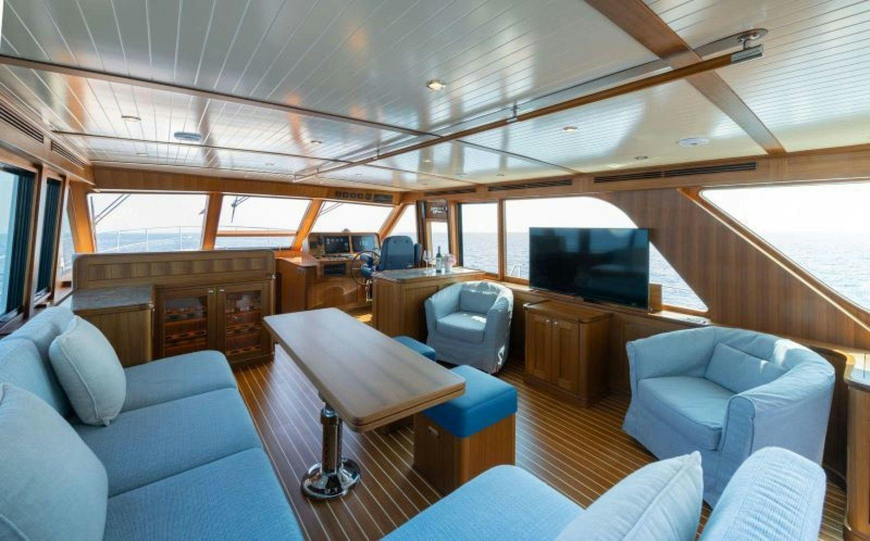 a room with a couch and a television in it aboard OCEAN 63 Yacht for Sale