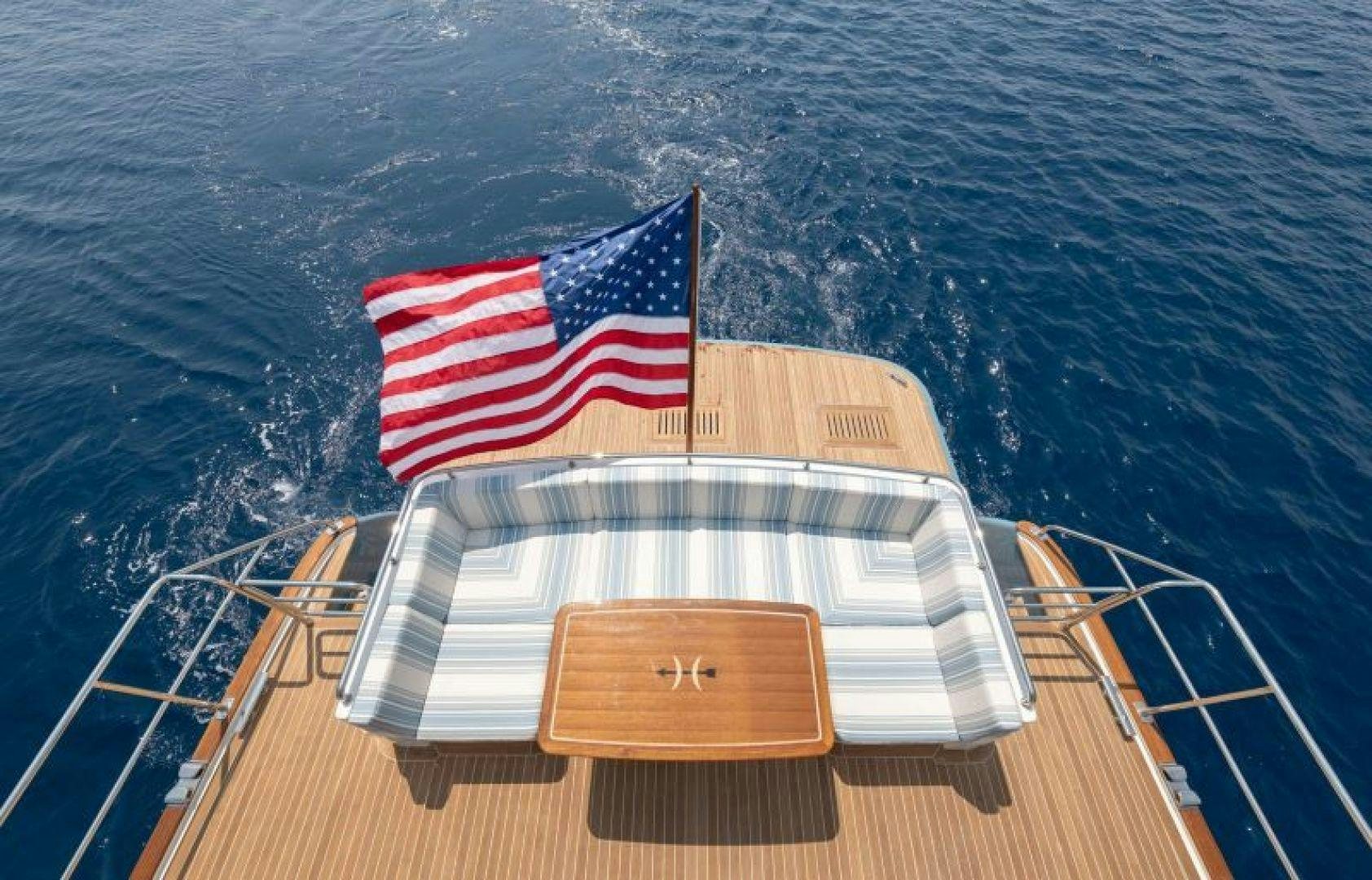 a boat with a flag on it aboard OCEAN 63 Yacht for Sale