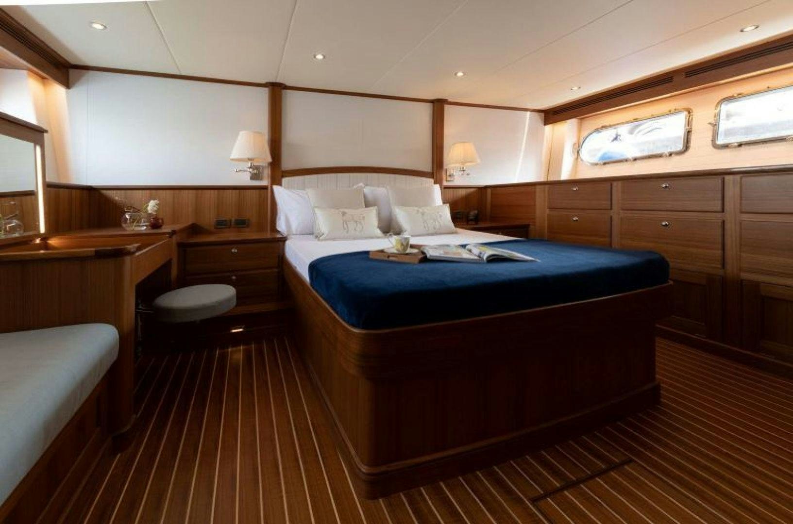 a bedroom with a bed and desk aboard OCEAN 63 Yacht for Sale