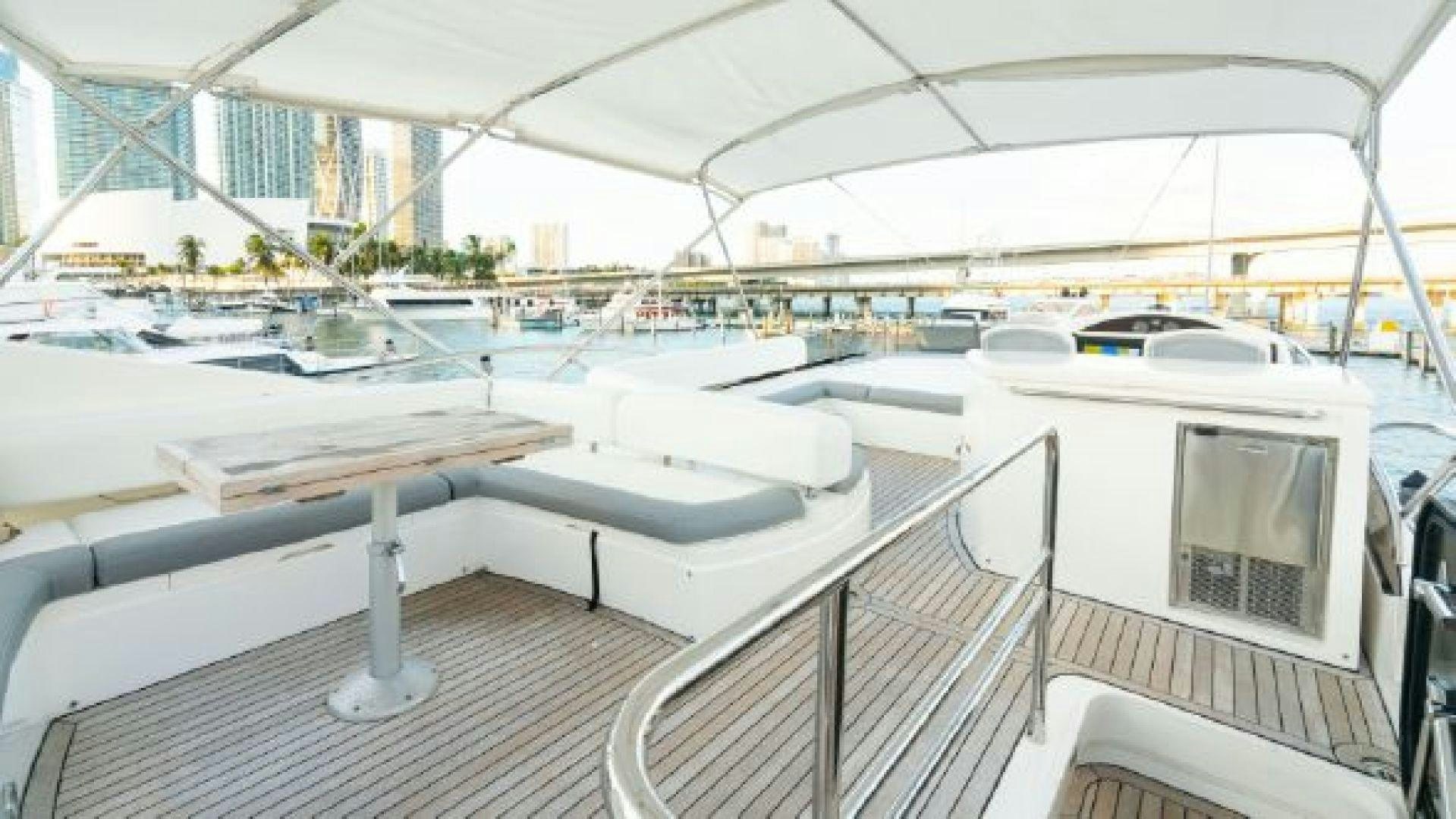 a deck with a table and chairs aboard MANCUSA Yacht for Sale