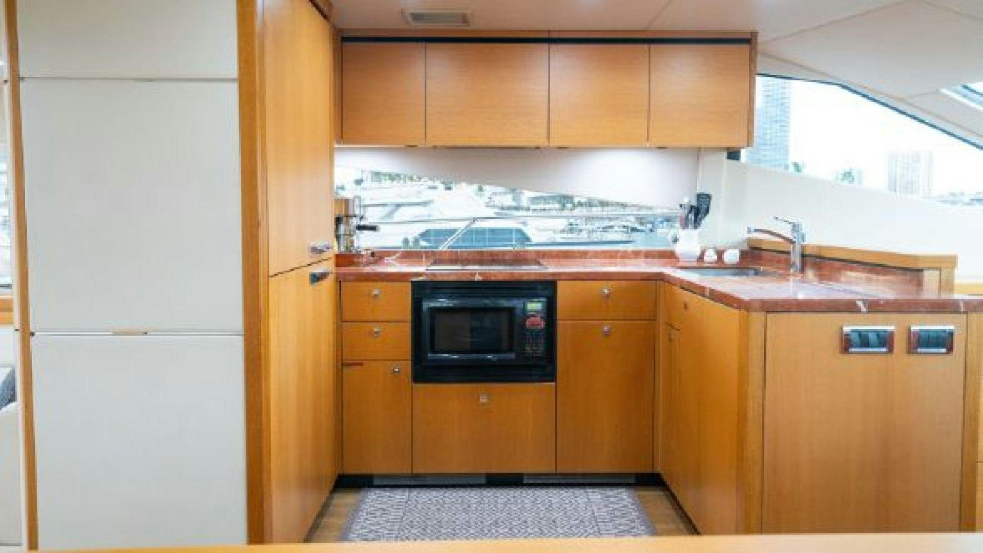 a kitchen with wooden cabinets aboard MANCUSA Yacht for Sale