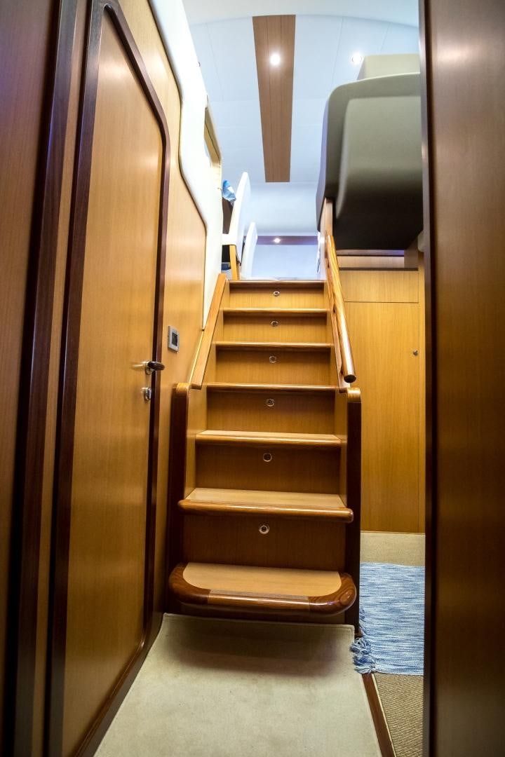 a wooden staircase with a wood railing aboard TESA Yacht for Sale