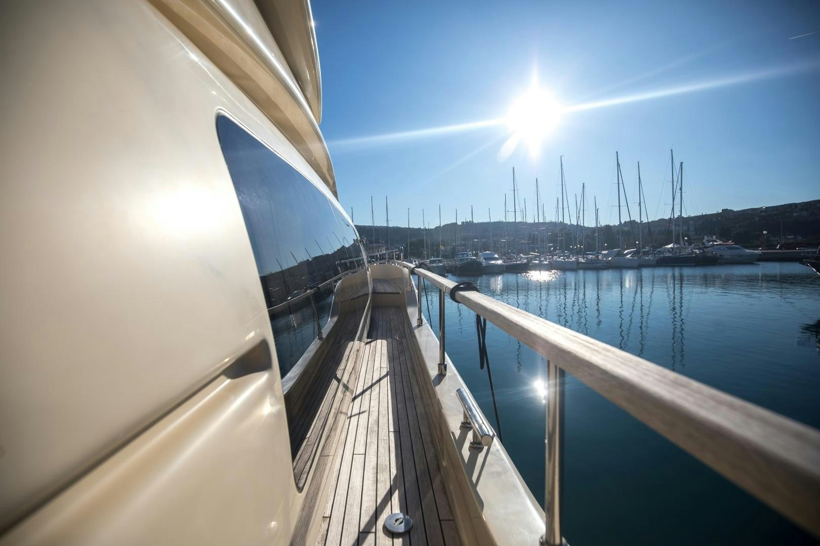 a deck with a railing and a body of water with boats on it aboard TESA Yacht for Sale