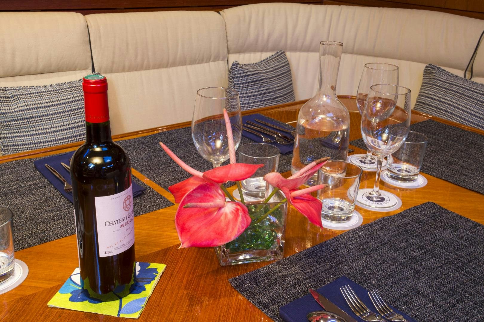 a table with wine glasses and bottles aboard simple harmony Yacht for Sale