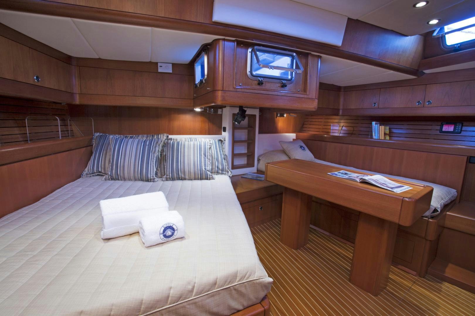 a room with a bed and desk aboard simple harmony Yacht for Sale