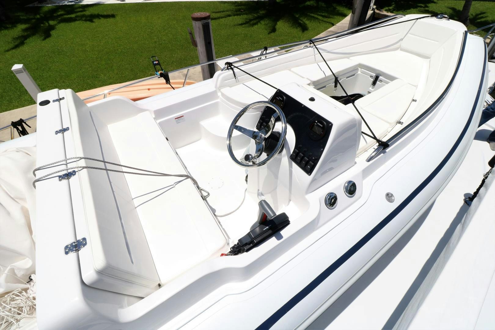 a white boat with a steering wheel aboard No Name Yacht for Sale