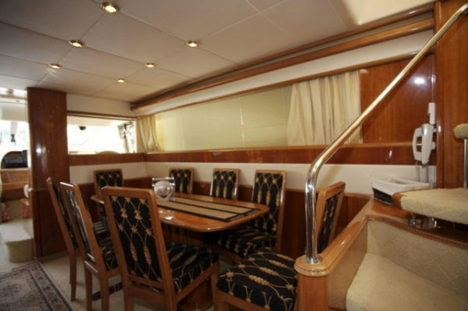 a dining table and chairs in a room with wood walls aboard LADY KARIMAN Yacht for Sale