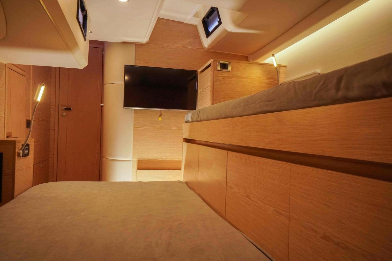 a room with a bed and tv aboard horizon Yacht for Sale