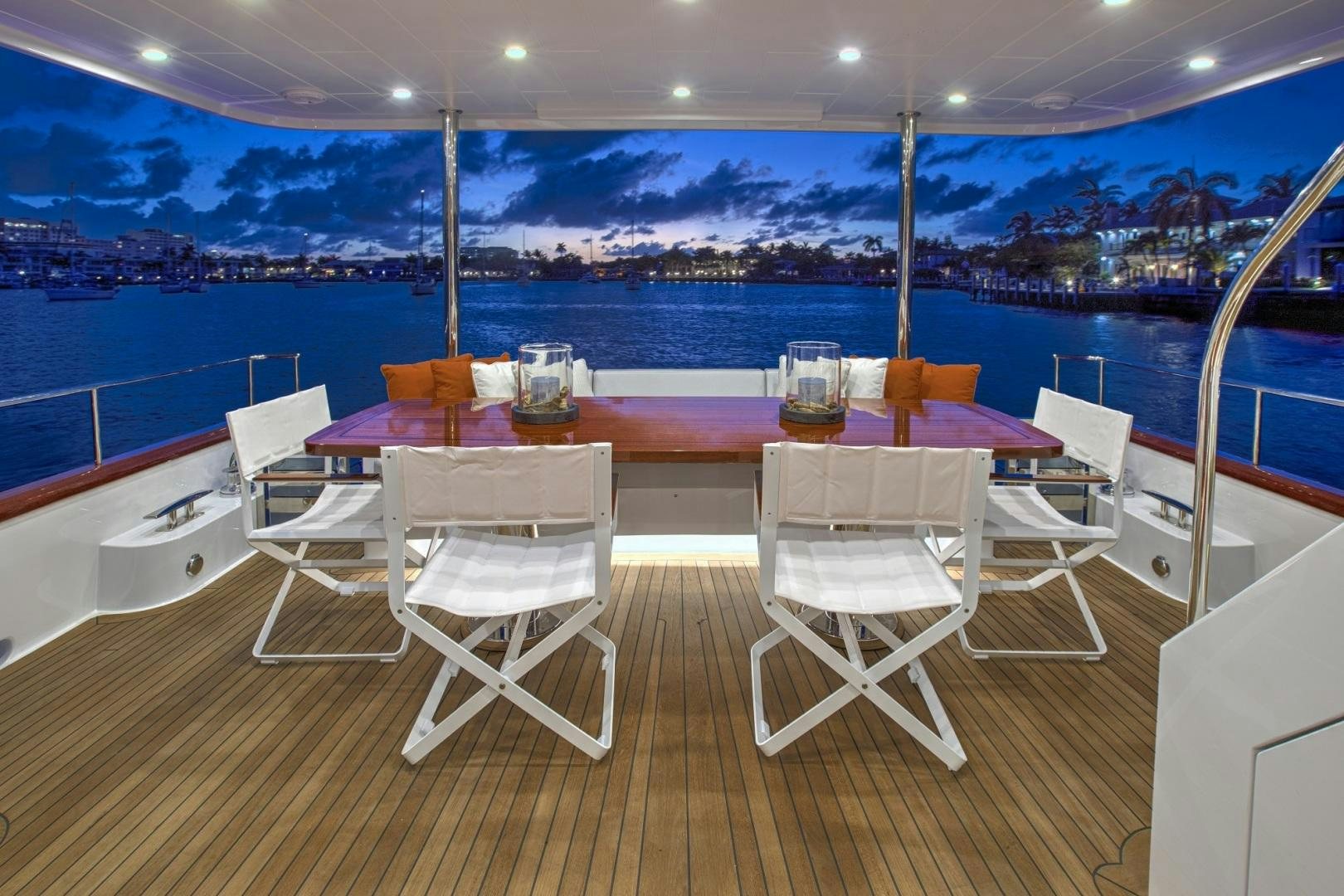 a table and chairs on a deck overlooking a city aboard 67 CRUISER Yacht for Sale