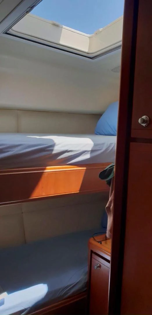 a person's feet on a wooden platform above a bed aboard BOUKI Yacht for Sale