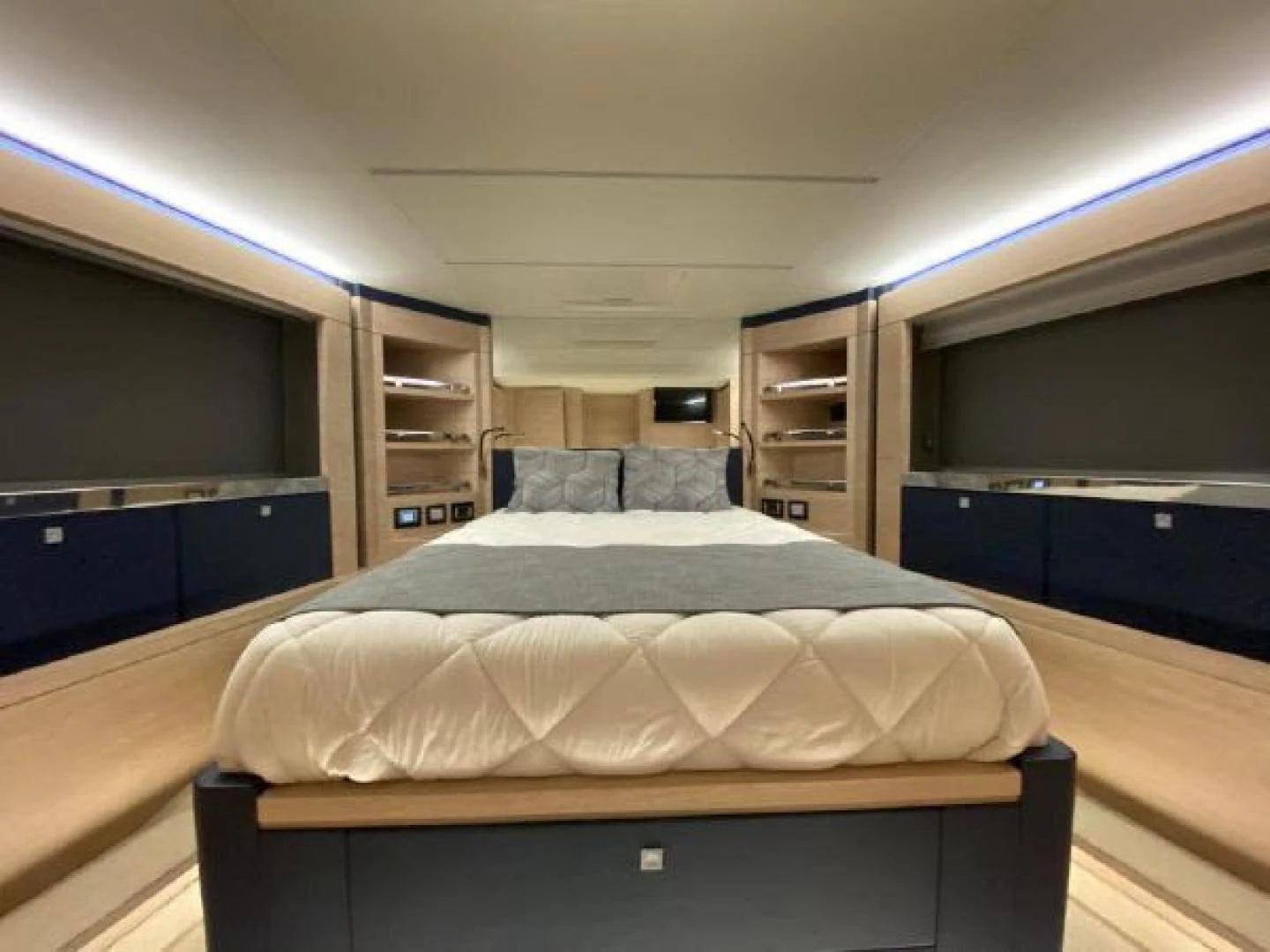 a bedroom with a bed and a bookcase aboard THE ONLY BLUE 66 FLY Yacht for Sale