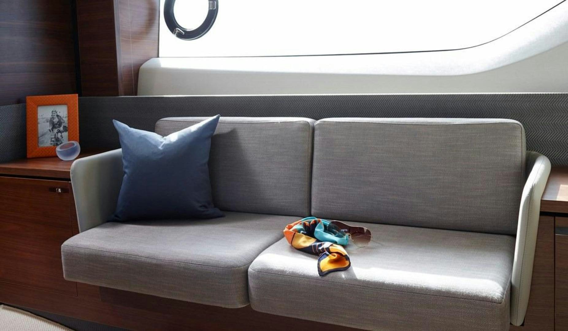 a couch with a blue pillow and a toy car on it aboard Namaste Yacht for Sale